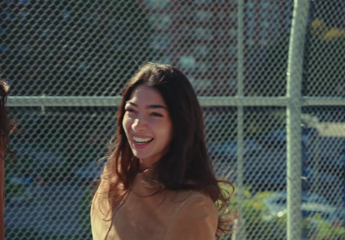 Woman smiles while walking outdoors on a sunny day