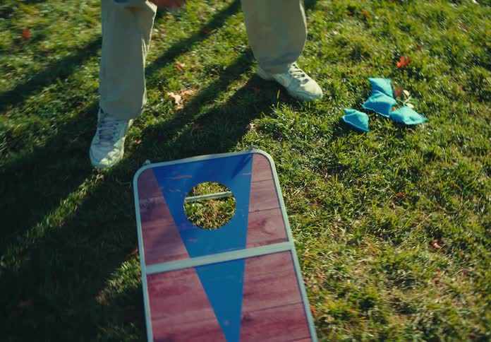 Man sets up a hacky sack target in the park located across the water from downtown on an autumn day