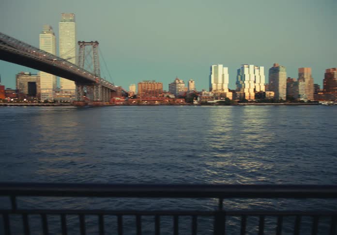 A river runs under a bridge leading into a city