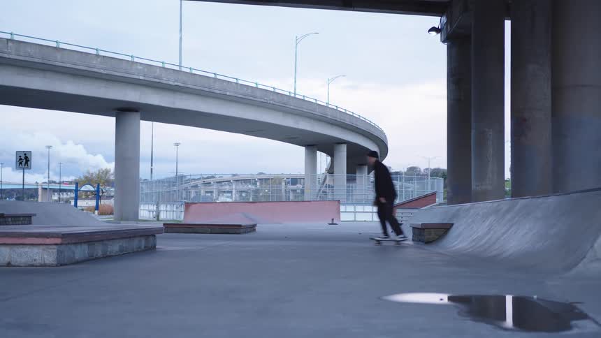 The man skateboards on ramps in the skate park