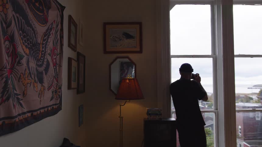 The man takes a picture from his window