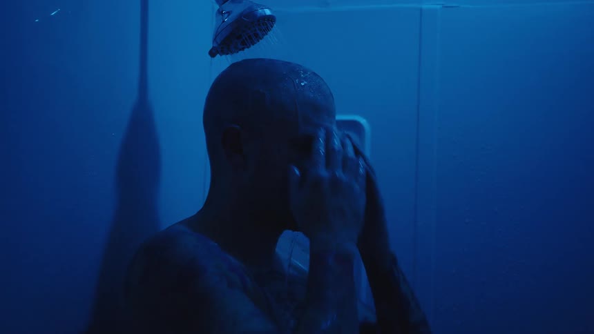 The man is showering in the dark
