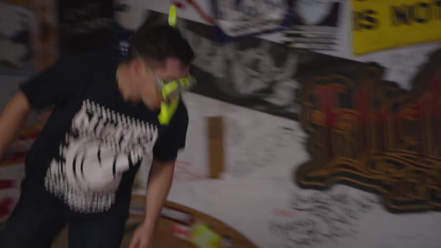 A young man skateboarding on a small indoor skate ramp during daytime