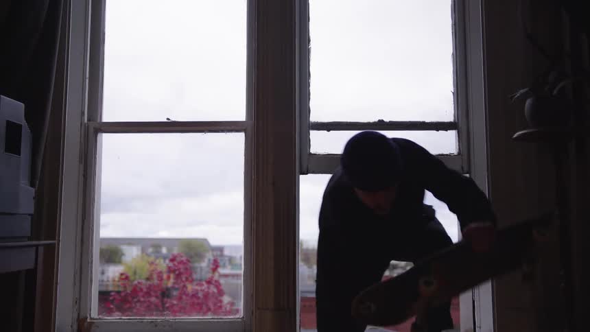 The man enters the home through a window