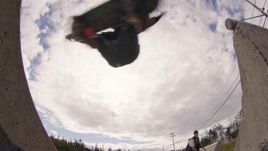 Skateboarder performs an aerial trick on a concrete obstacle