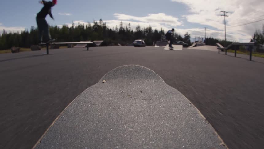 Skateboarder performing a trick on the skatepark with a view of the background scenery