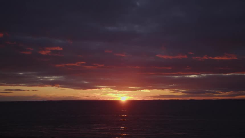 Sun setting in the afterflow on the horizon over the ocean
