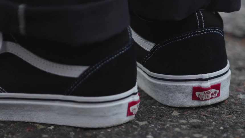 A persons black and white shoes
