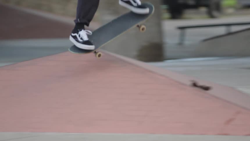 A young man skateboarding at an outdoor skating ramp in the city during daytime