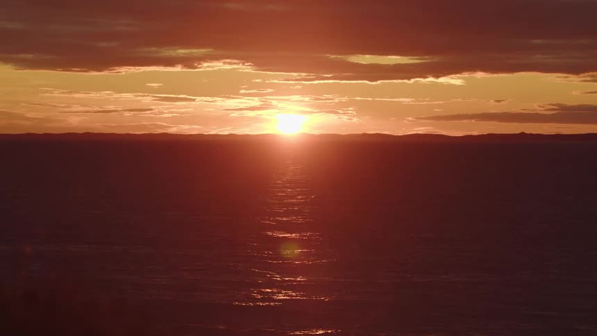 A beautiful orange sunset over the ocean with shimmering water