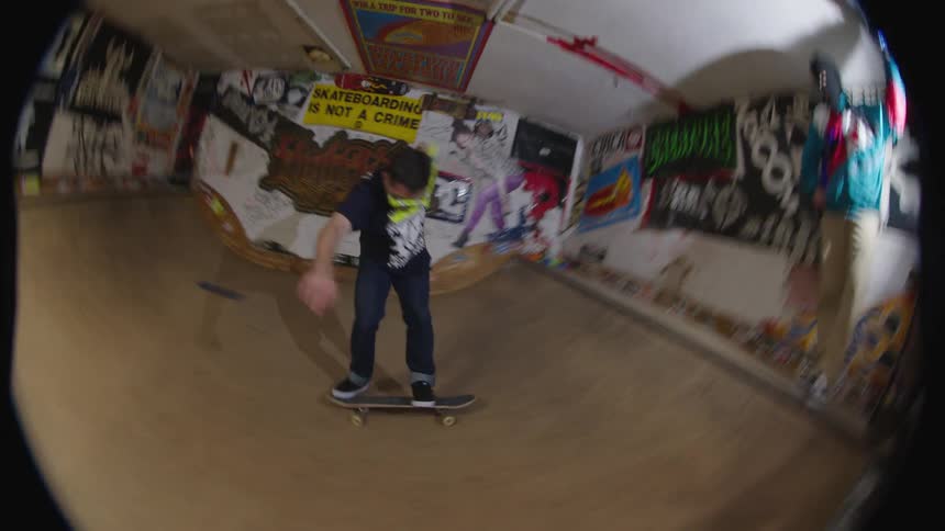 A man skateboards inside