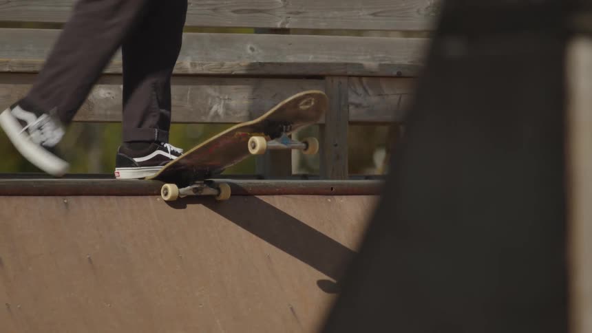 The person rides the ramp down on a skateboard