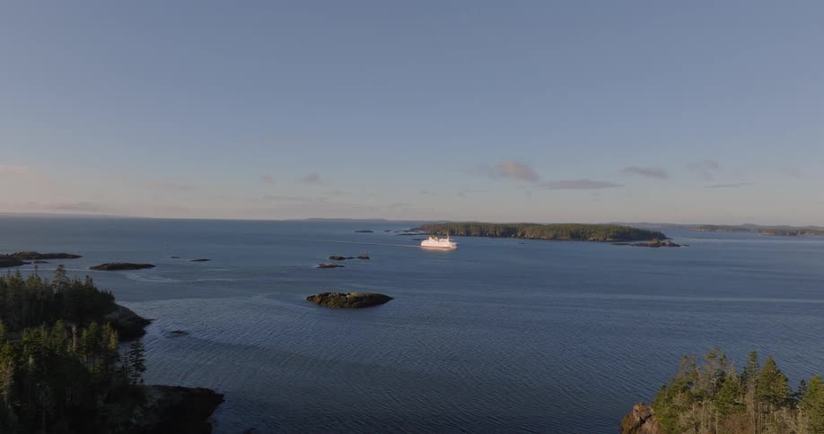A ship sails by a rocky island