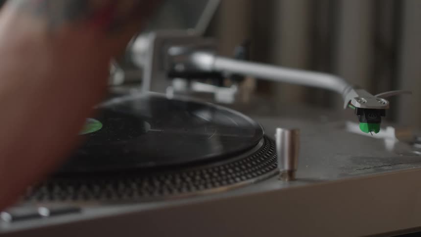 A person puts a record in the record player