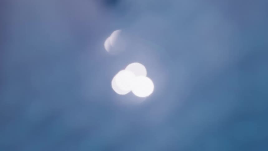 Soft reflections of blurred lights float against a blue background