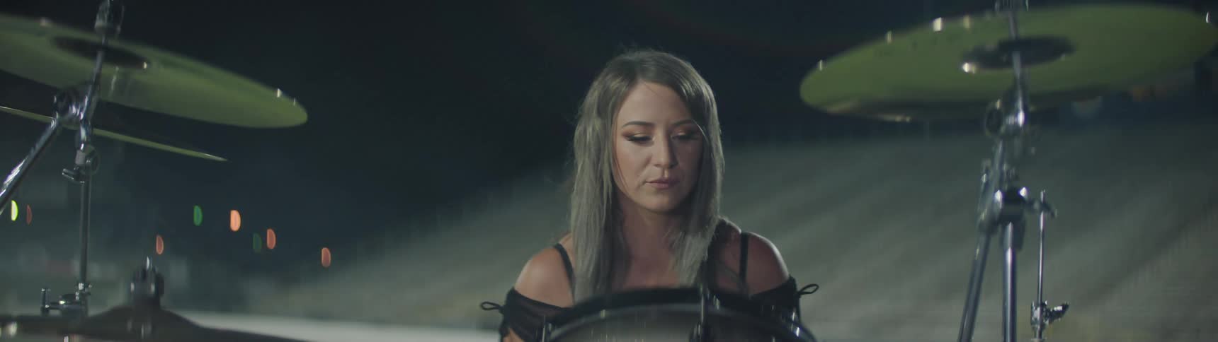 A drummer sits at her drums