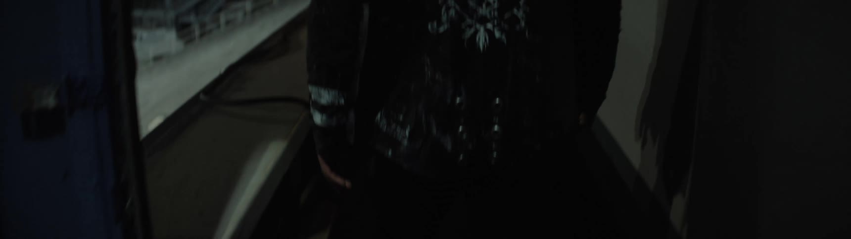 The video is a closeup of a persons feet wearing dark boots and pants as they step onto a rough patterned metal floor the background is dark and the shot focuses only on the foot movement and the texture of the floor