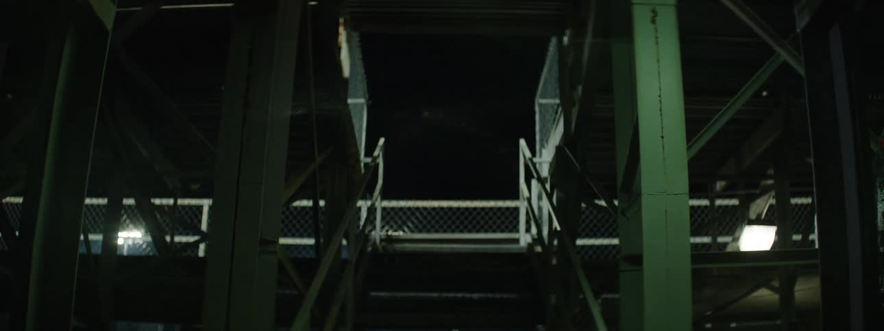 The man walks by the staircase at night
