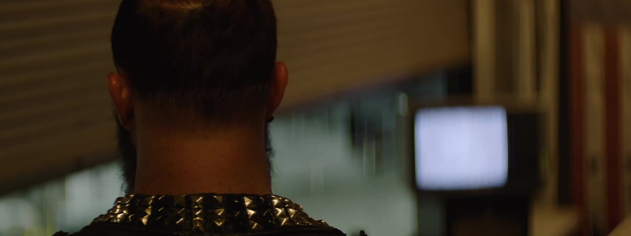 Man watches a bright screen in a dimly lit indoor setting