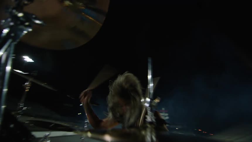 Female drummer plays the drums in an empty stadium at night