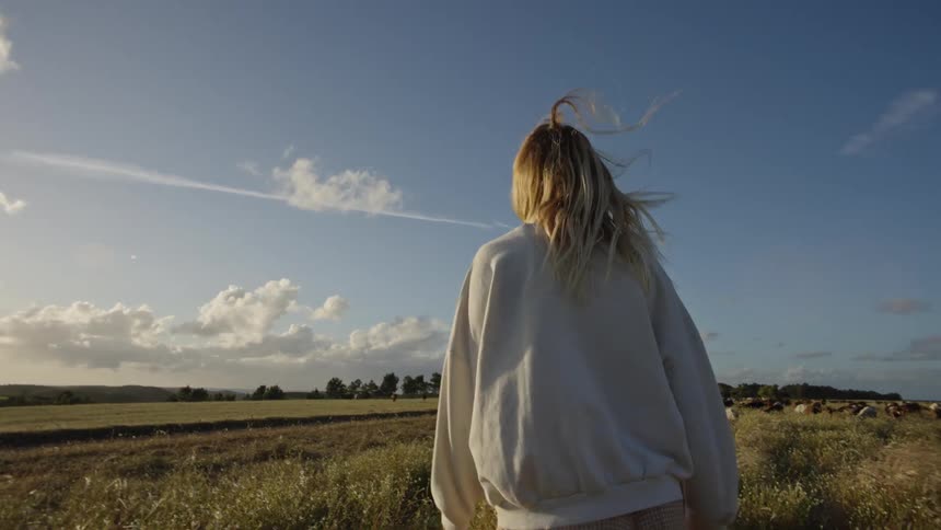A lady walks through a field