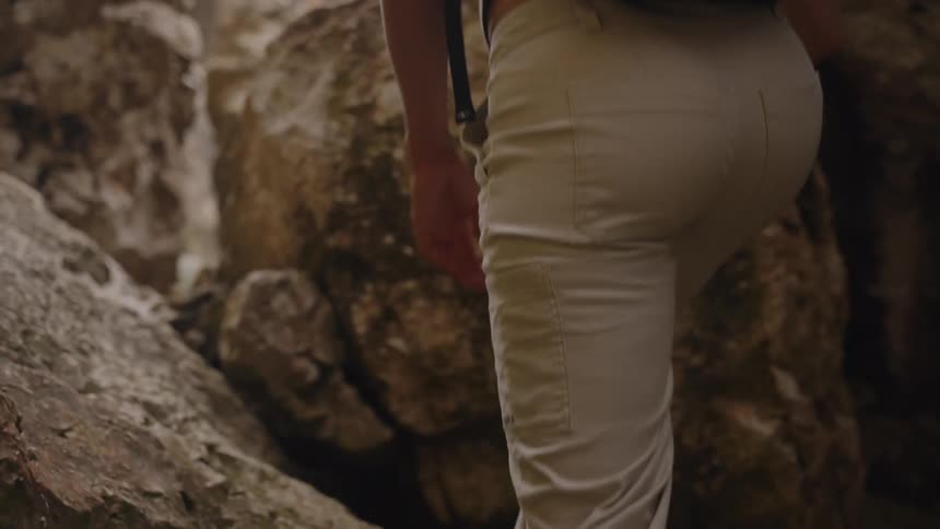 Person climbing steep rocks with a backpack on their back