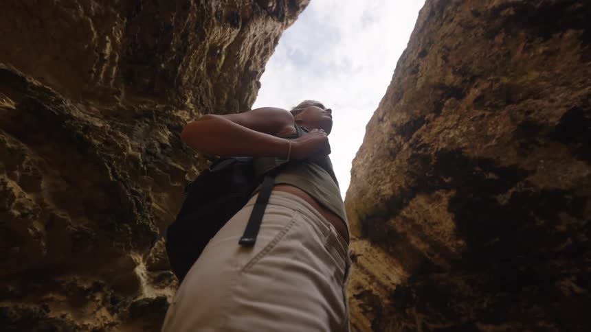 A woman looking up while standing in a canyon