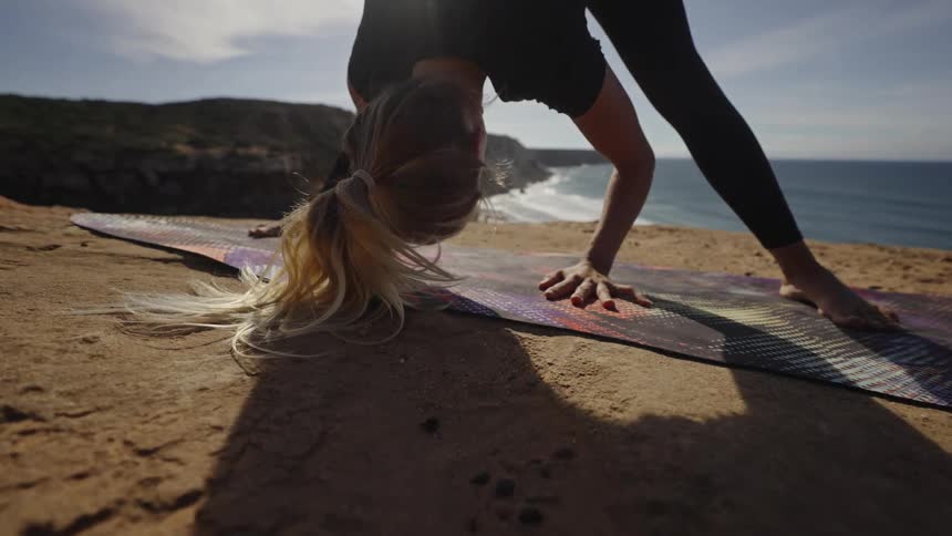 A woman doing yoga at the coast