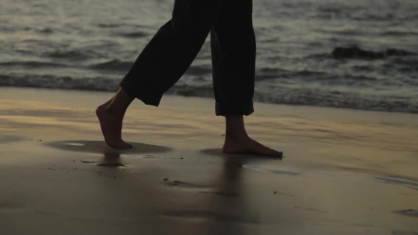 A person walks along the beach