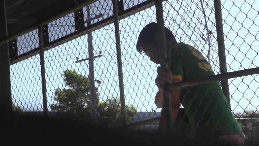 Man opening and walking through a fence