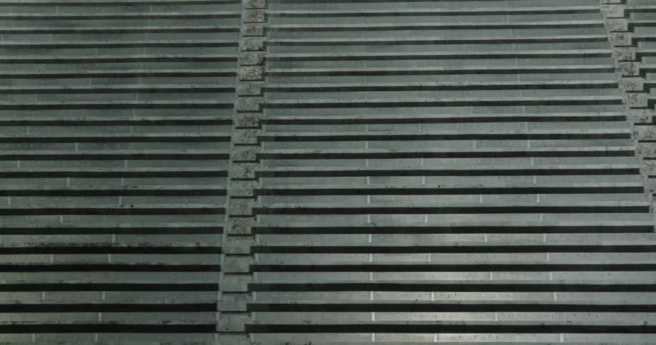 Columns containing multiple raised strips cover a building facade