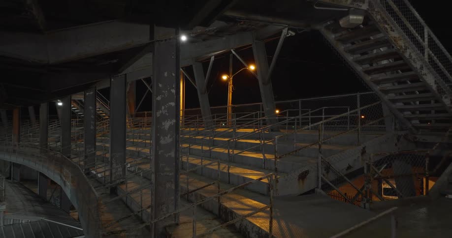Empty metal stands and staircases under dim night lighting