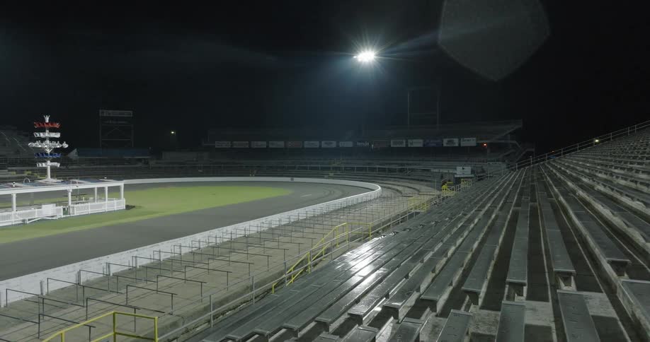 Bright field lights illuminate an empty stadium