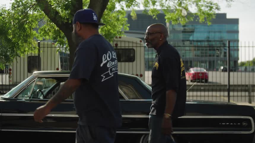 Two men walk down the street together