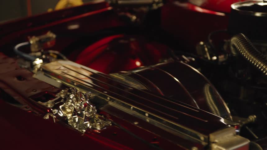 Chrome engine of a classic car with illuminated red details