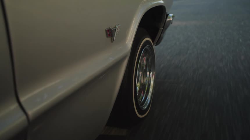 Wheel of a classic car moving along the asphalt