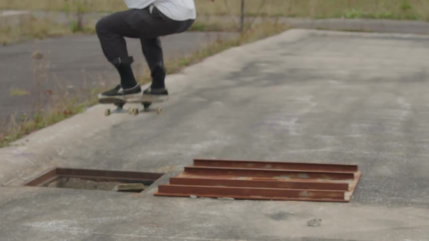 The man skates down the ramp and jumps over a hole