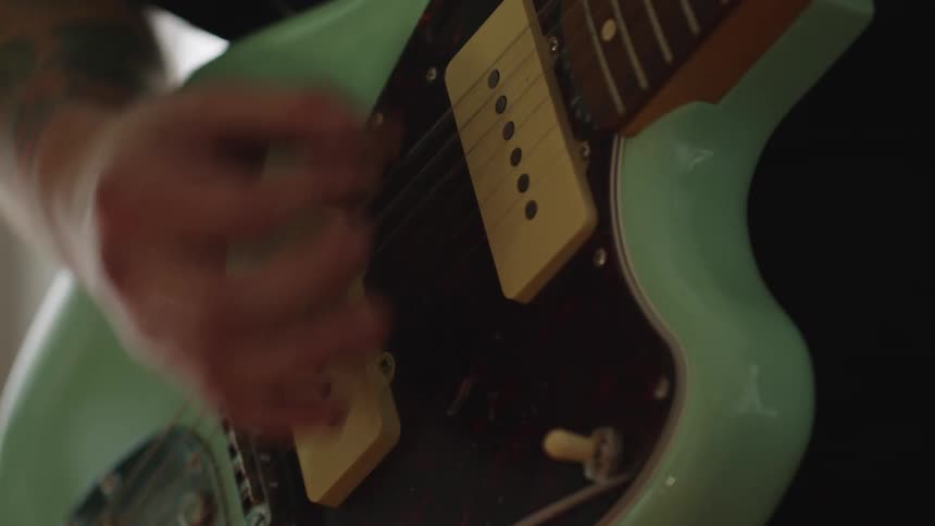 The man is playing the guitar