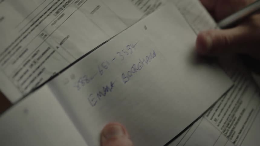 The person takes notes in his book