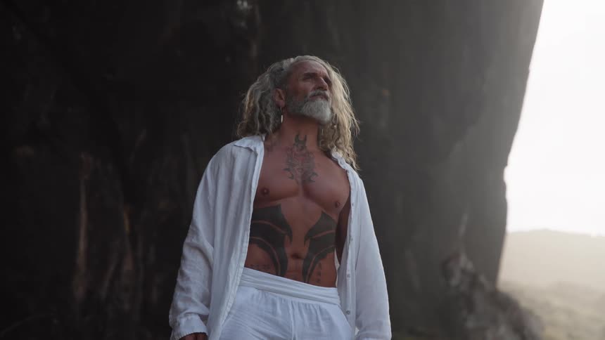The man stands by the foggy mountain