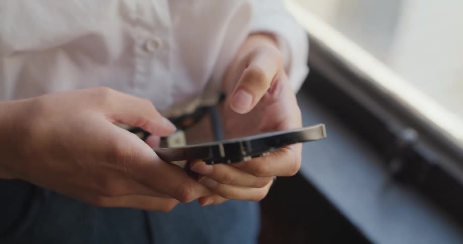A persons hands holding and using a cellphone