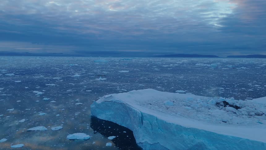 Icebergs floating in the ocean under a cloudy sky