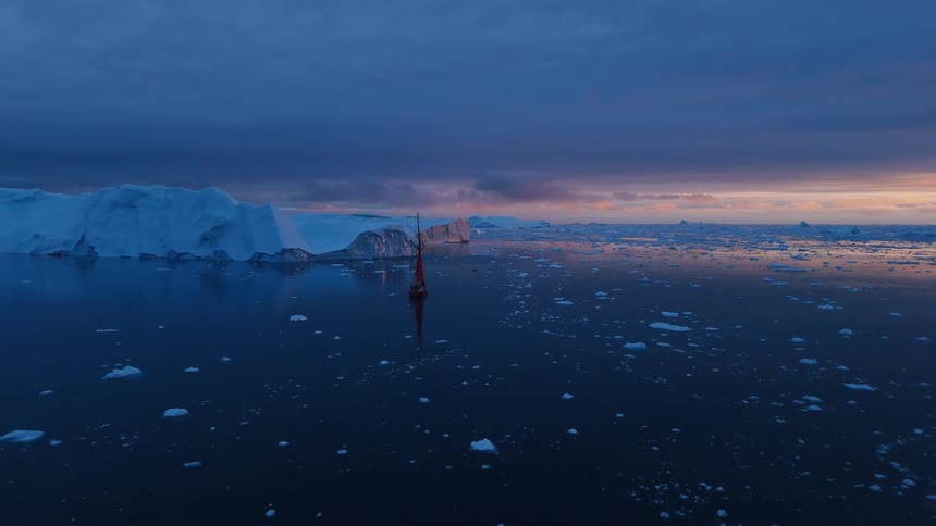 Camera drifting among icebergs under a colorful sky