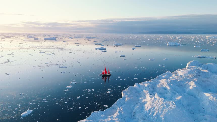 Boat sailing off the arctic coast among icebergs and floating ice