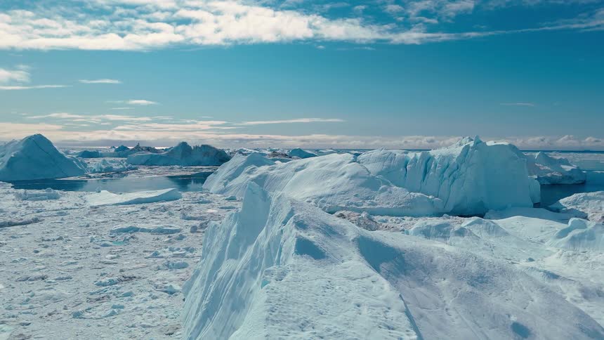 Sunlight shines on glaciers and icebergs on arctic water