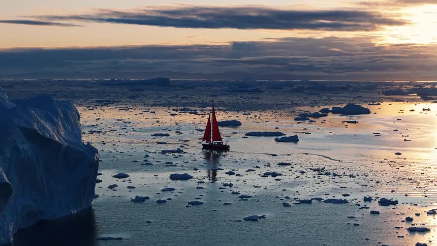 Boat sailing off the arctic coast among icebergs and floating ice