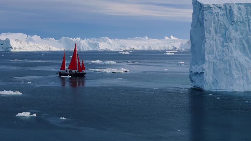 Boat sailing off the arctic coast among icebergs and floating ice