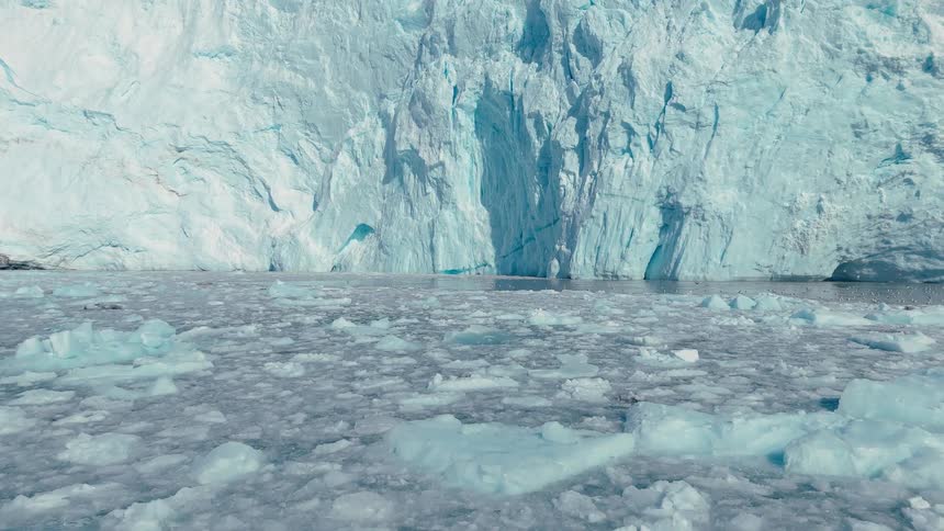 Glaciers and melting ice as birds fly along the arctic coast