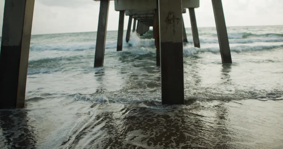 The waves hit the posts of the pier