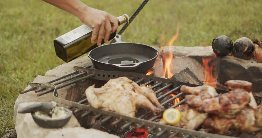 Oil is poured into the pan as the chicken is grilling outside